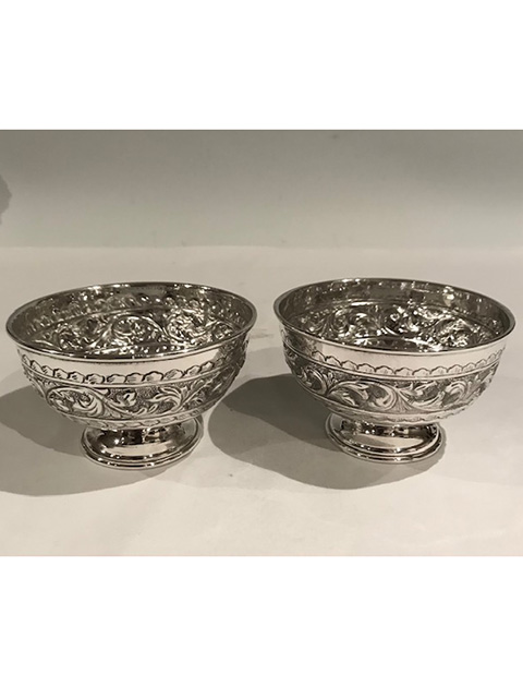 Pair heavily embossed antique silver plated small bowls standing on pedestal bases suitable for olives, bon bons or trinkets